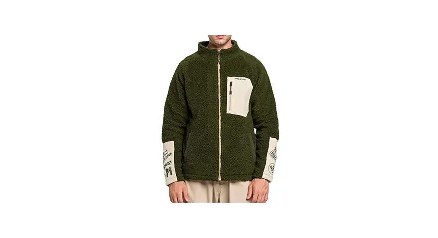 Giacca sherpa verde Stüssy con tasca beige e dettagli grafici sulle maniche. Perfetta per un look urbano e casual.