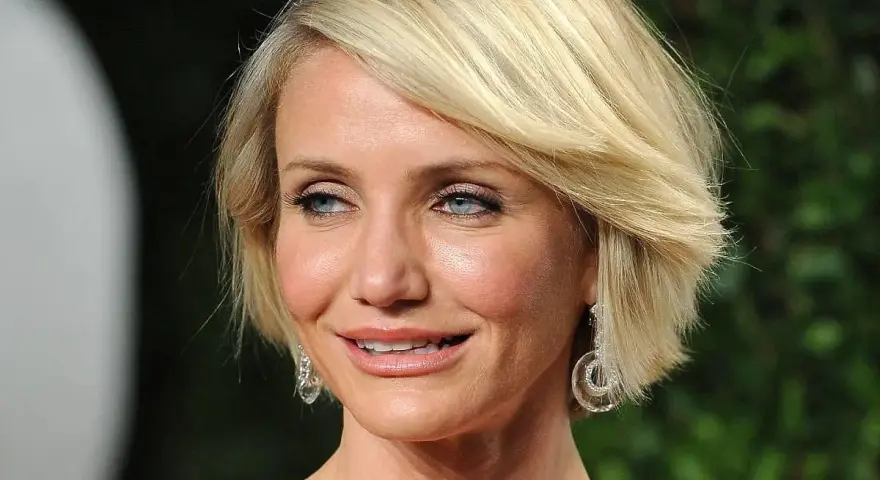 Cameron Diaz w stylowej fryzurze bob, idealnej dla okrągłej twarzy po 50. roku życia, z błyszczącymi kolczykami.