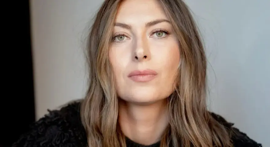 Kobieta z piwnymi oczami, o delikatnym spojrzeniu, w czarnym, futrzanym swetrze.