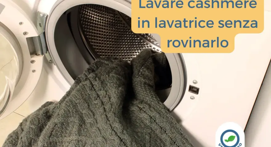 Un maglione di cashmere grigio viene inserito in una lavatrice. Impara come si lava il cashmere in lavatrice senza rovinarlo.