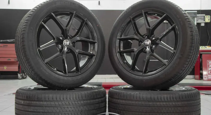 Cerchi in lega neri lucidi con logo Alfa Romeo, perfetti per un'Alfa Romeo Stelvio. Gomme Michelin Latitude Sport 3.