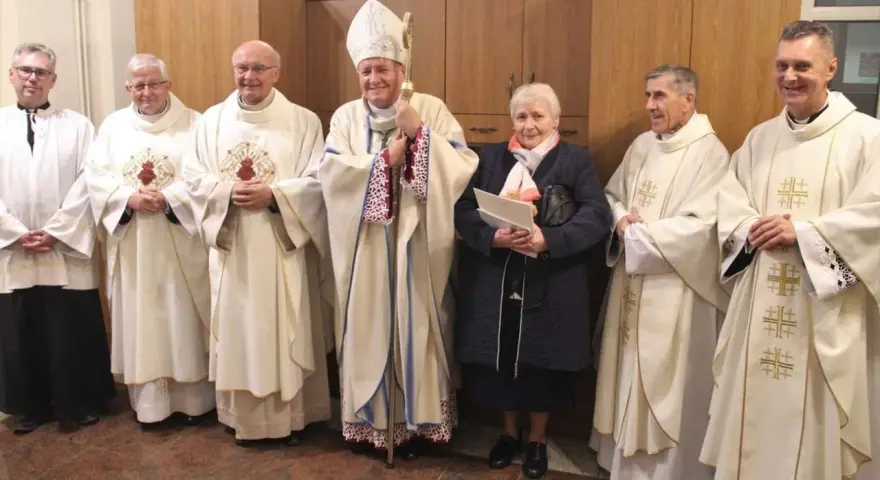 Uroczystość z udziałem biskupa i duchownych. Wśród nich stoi kobieta, która jest wdową konsekrowaną.