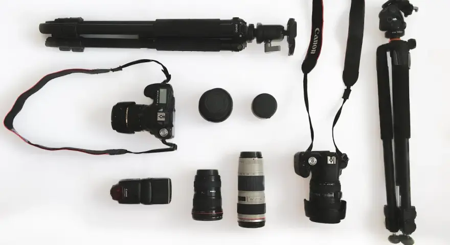 Ensemble d'un appareil photo reflex, d'objectifs, d'un flash et de trépieds, prêt pour une séance photo.