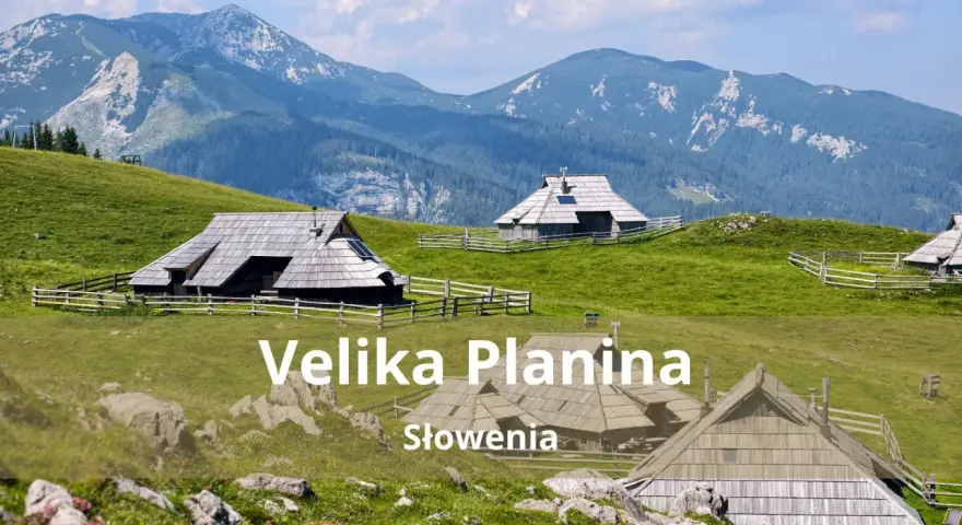 Tradycyjne drewniane domki pasterskie na zielonych wzgórzach Velika Planina w Słowenii, z majestatycznymi górami w tle.