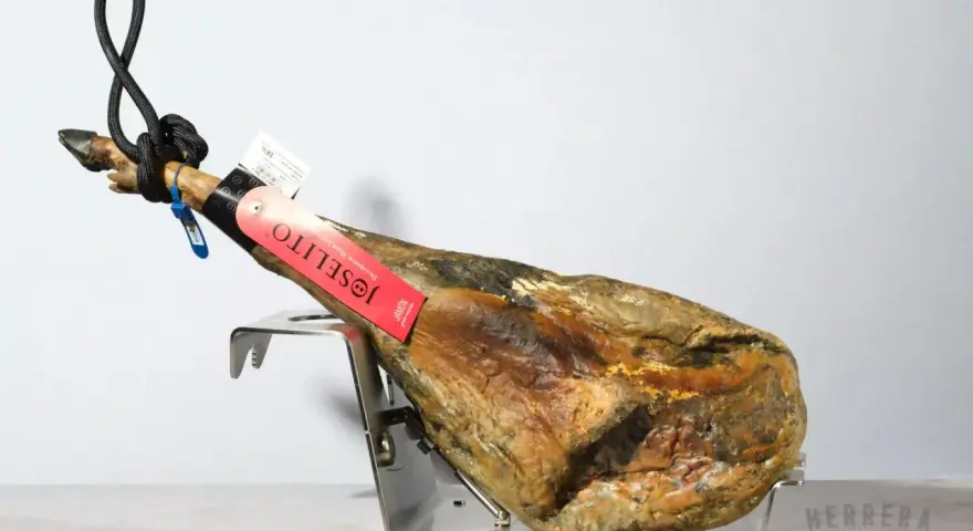 Jamón Joselito en soporte metálico, con etiqueta roja y negra.