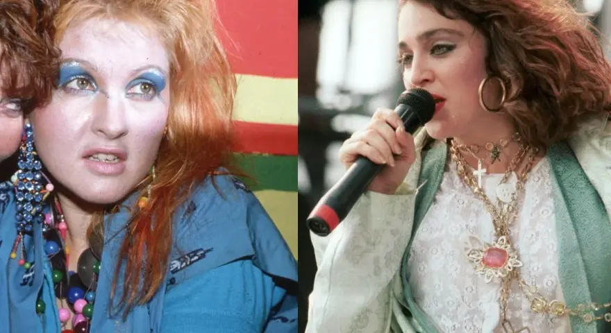 Ikony lat 80. w ekstrawaganckich stylizacjach na imprezę: Cyndi Lauper z kolorowym makijażem i Madonna z krzyżykami na szyi.