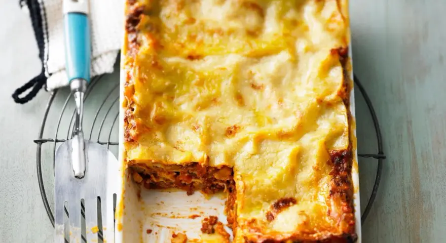 Eine frisch gebackene, goldbraune Lasagne mit geschmolzenem Käse, die Lust auf diese perfekte Lasagne macht.