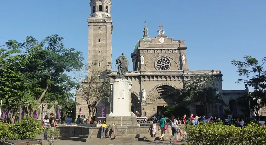 Manila Cathedral, symbol Filipiń religia. Ludzie spacerują przed monumentalną budowlą, podziwiając architekturę i atmosferę.