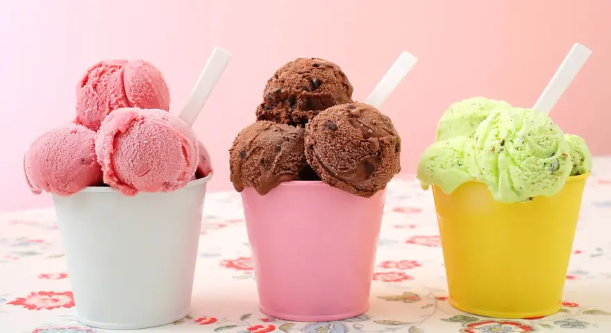Trzy kubeczki z lodami: różowe, czekoladowe i pistacjowe. Który wybierasz: sorbet owocowy czy lody mleczne?