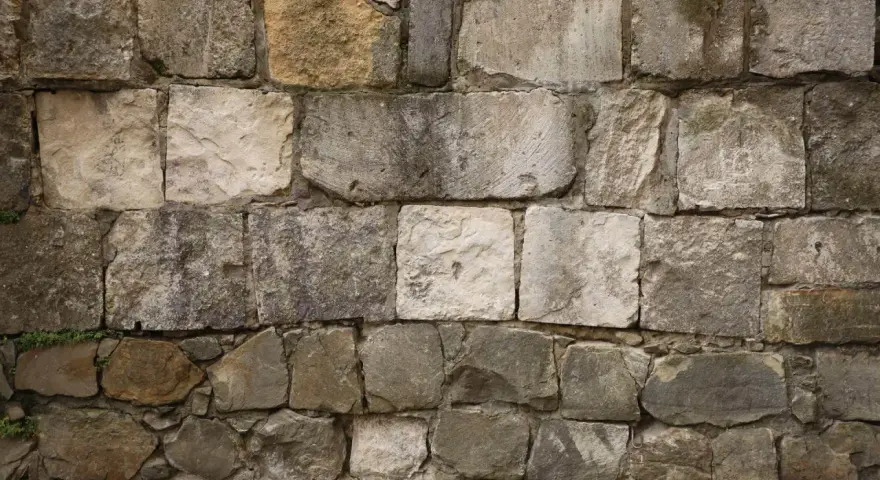 Mur en pierres naturelles, certaines semblant prêtes à décaper pour révéler leur éclat d'origine.