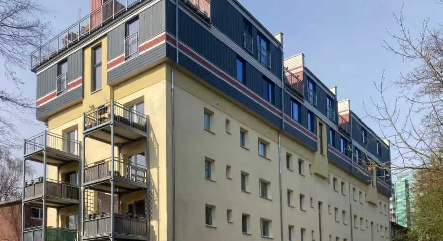 Modernes Mehrfamilienhaus mit Balkonen und auffälliger Fassadengestaltung im **Vorort**.