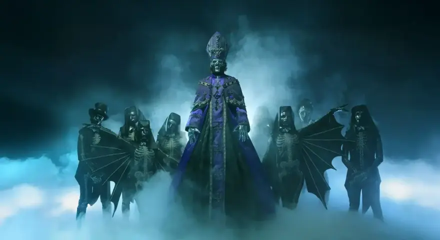 Le groupe de musique Ghost, avec son leader en tenue papale violette, entouré de musiciens aux costumes squelettiques et masqués, émerge d'une brume bleutée.