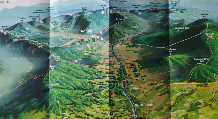 Mapa turystyczna z zaznaczonymi szlakami z Brennej. Widok na góry, lasy i doliny z wioskami.