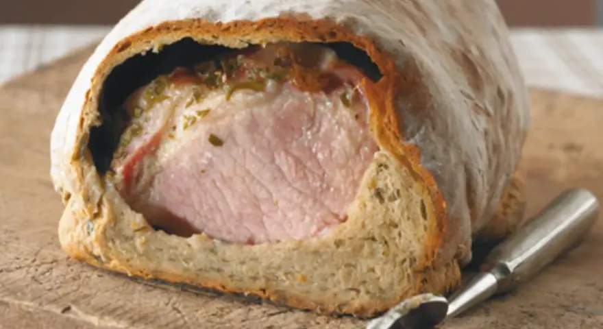 Saftiges Kassler im knusprigen Brotmantel, bereit zum Anschneiden. Ein Festmahl!
