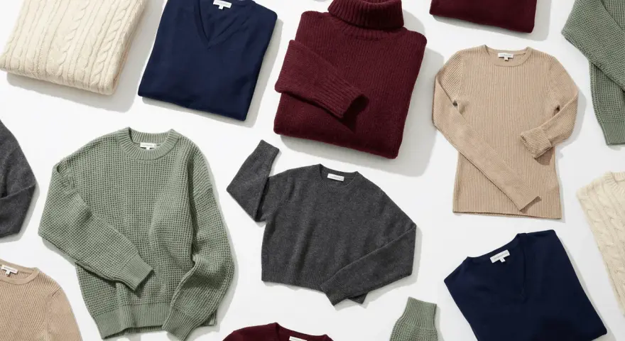 Una collezione di maglieria in varie tonalità: beige, blu, bordeaux, grigio e verde. Il maglione a trecce beige evoca un senso di calore e tradizione, mentre i modelli a collo alto e scollo a V offrono eleganza.