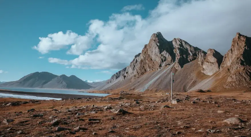 Krajobraz Islandii z górami i jeziorem. Wietrzna reykjavik pogoda z chmurami na niebie.