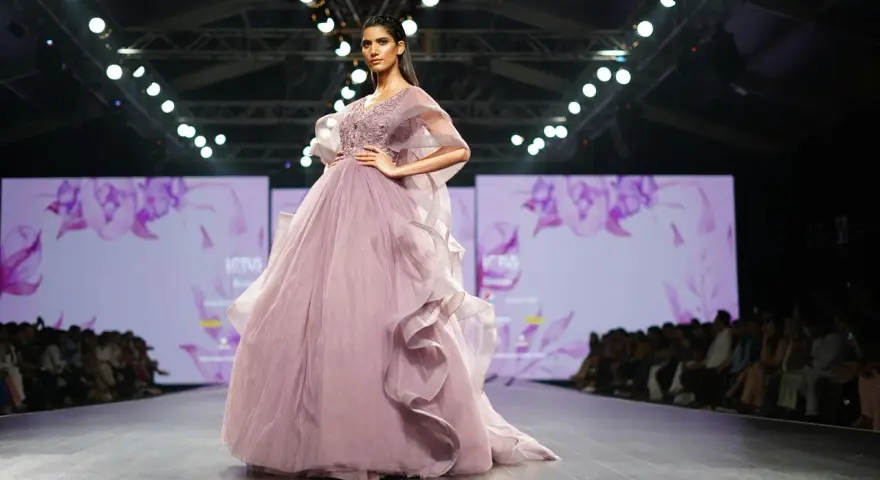 Modelka prezentuje suknię haute couture z muślinu i tiulu na pokazie mody.