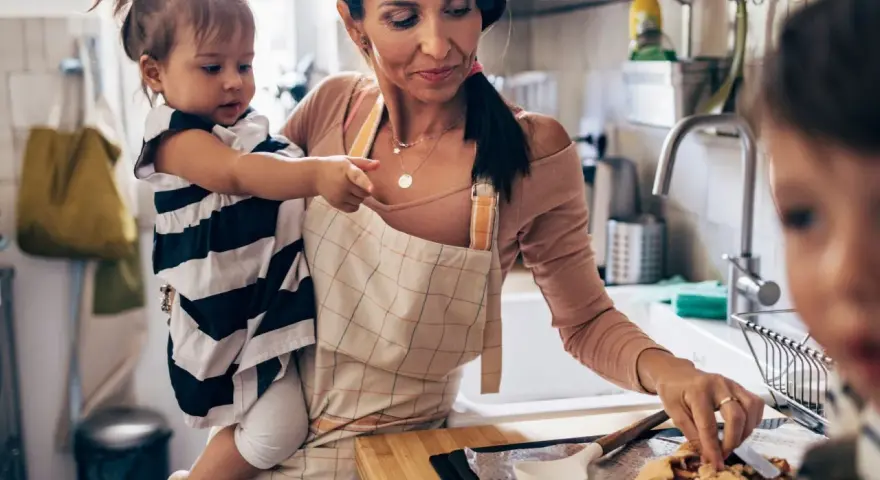 Mutter mit Kleinkind in der Küche, die gemeinsam backen. Tolle Ideen für Rezepte Kleinkinder.