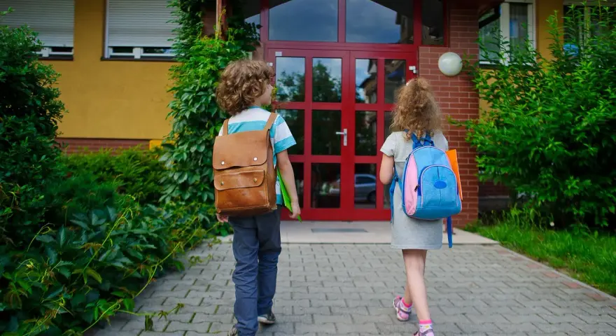Dwoje dzieci z plecakami idzie do szkoły. Zastanawiasz się, ile razy można powtarzać klasę w liceum?