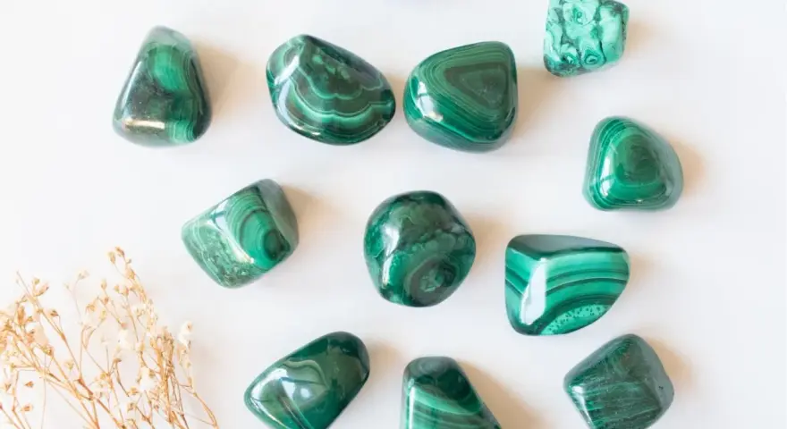 Tumbled malachite stones with their characteristic green bands, showcasing the beauty and potential malachite proprietà.