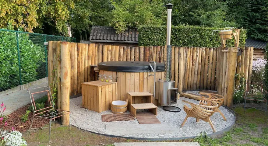 Entspannende gartendusche ideen: Ein Whirlpool mit Holzverkleidung, daneben ein Holzofen und Sitzgelegenheiten aus Holz.