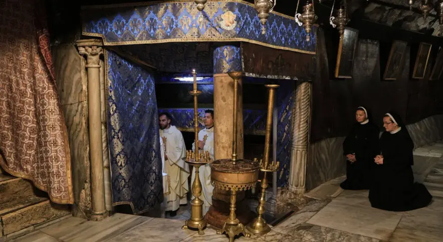Im Inneren der Geburtsgrotte, wo ist Jesus geboren, stehen Priester und Nonnen in Andacht.