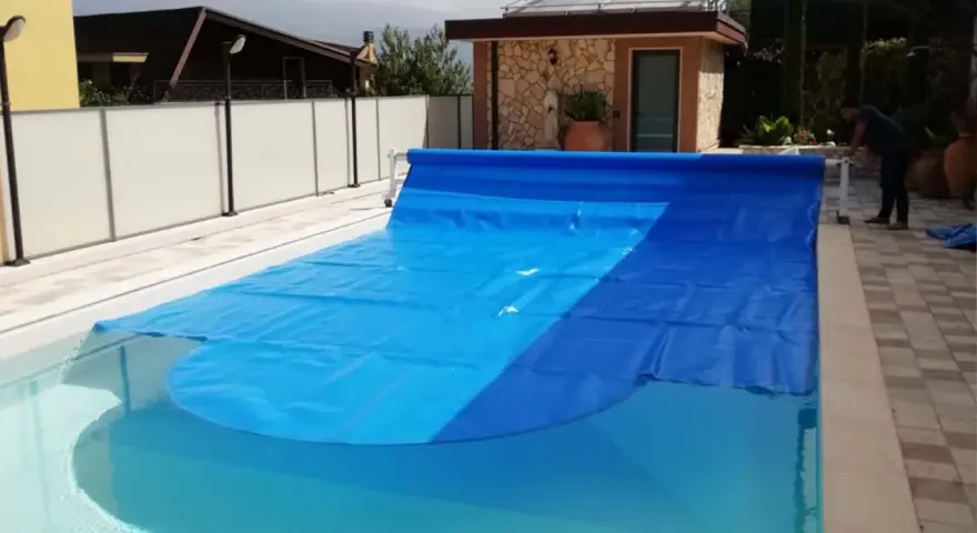 Cubierta azul para piscina, ideal para saber como calentar el agua de la piscina y mantenerla limpia.