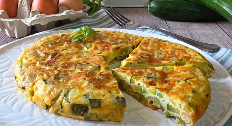 Una gustosa frittata di zucchine, dorata e soffice, con zucchine fresche, uova e basilico. Perfetta per un pasto leggero.
