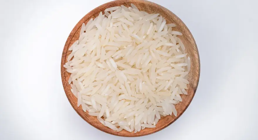 Miseczka z ryżem parboiled na białym tle.