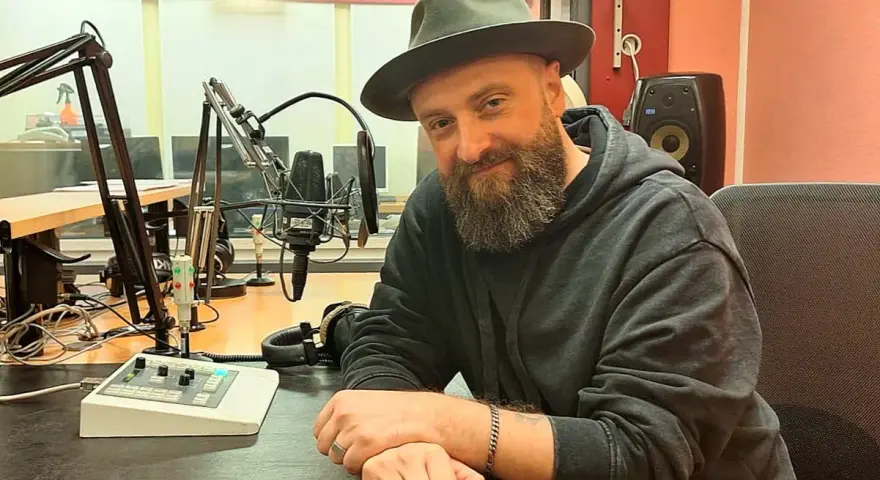 Łukasz Drapała w studio radiowym, gotowy na szalony bal dźwięków.