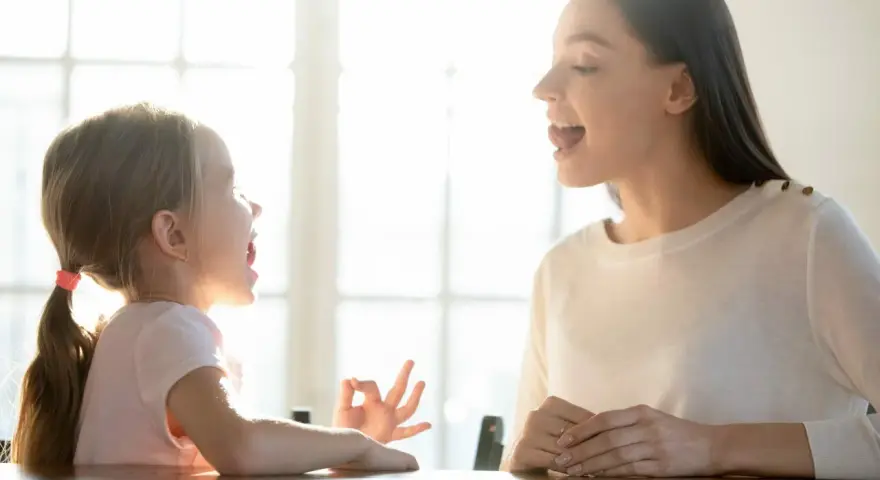 Mama uczy córkę mówić, a dziecko zaczyna rozumieć co się do niego mówi.