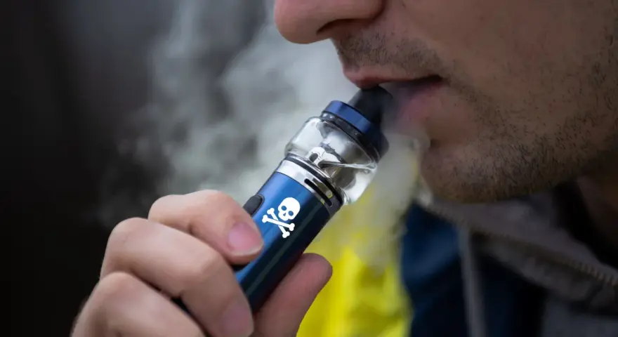 Persona vapeando un dispositivo con calavera, advirtiendo sobre los vapear efectos secundarios.