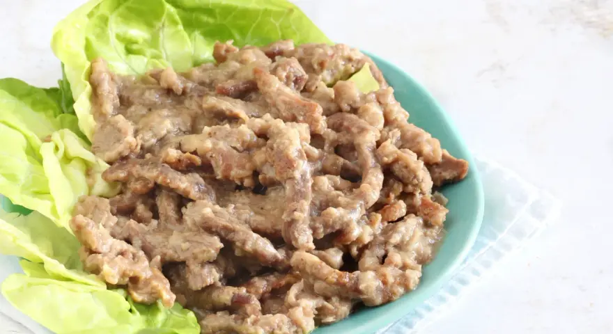 Straccetti di manzo succulenti serviti su foglie di lattuga fresca, un piatto invitante e saporito.