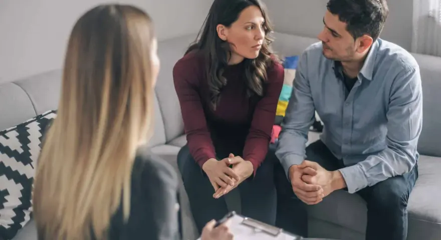 Un couple discute avec un psychiatre lors d'une séance de thérapie de couple.