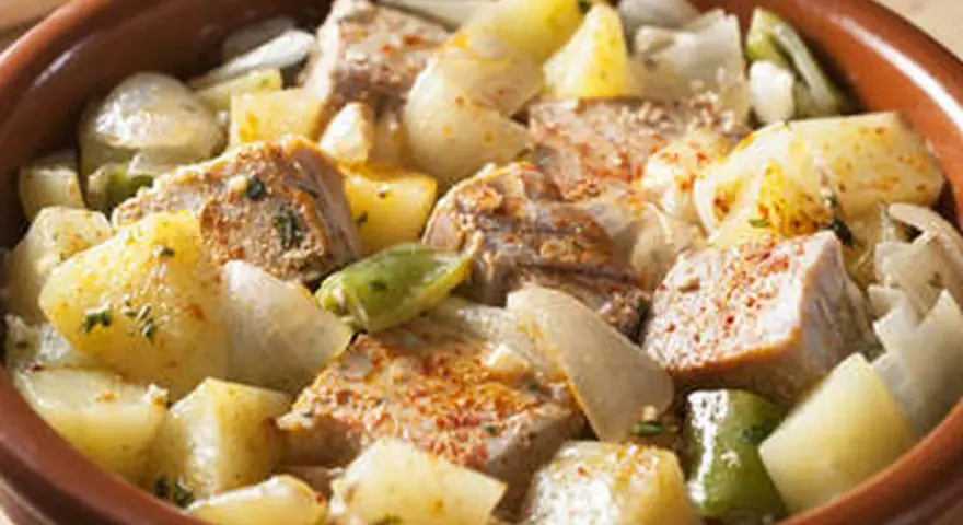 Un delicioso marmitako de atún con patatas, pimientos y cebolla en una cazuela de barro.