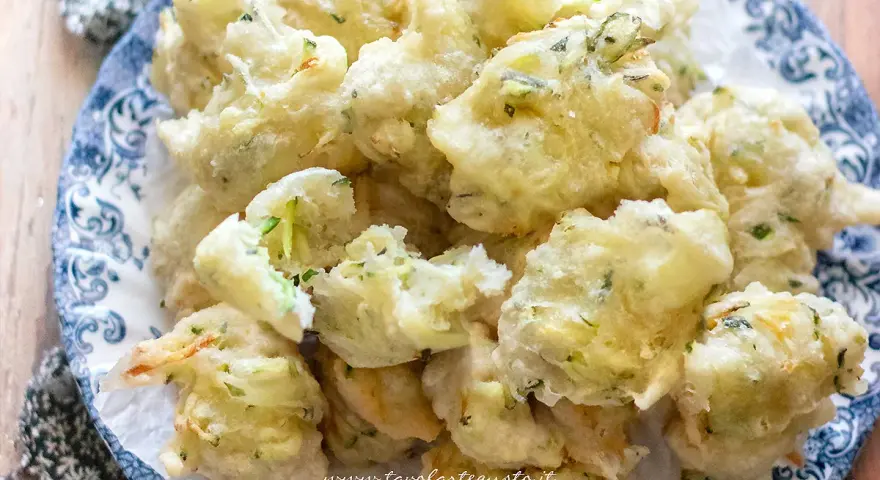 Frittelle di zucchine dolci, dorate e croccanti, servite su un piatto decorato. Un'esplosione di sapore!