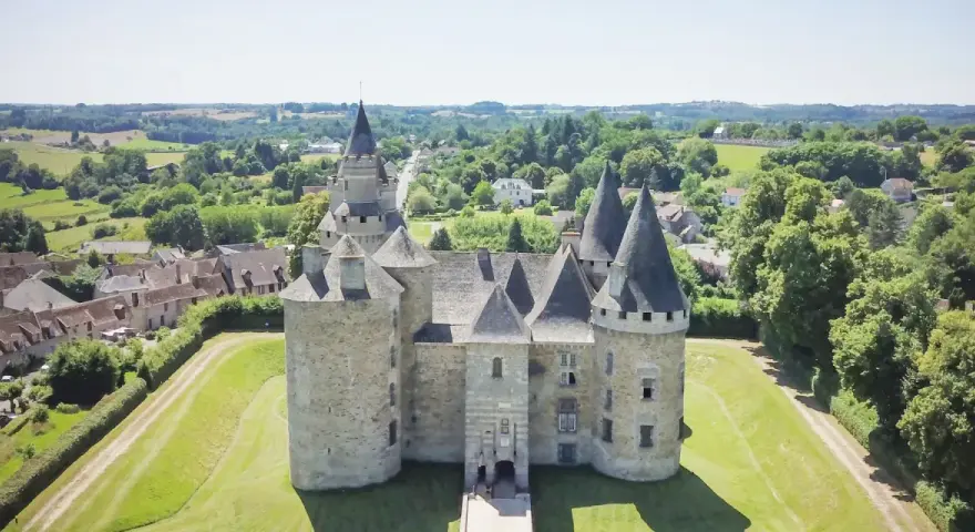 Le château de Bonneval, un joyau médiéval, se dresse fièrement au milieu d'un paysage verdoyant, entouré d'un village pittoresque.