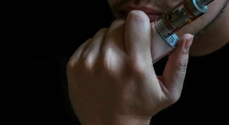 Persona vapeando, disfrutando de los mejores sabores vaper.