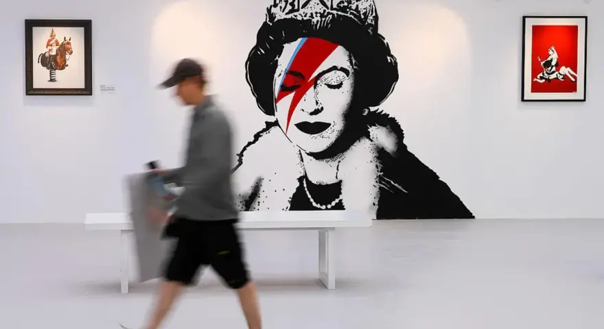 W galerii sztuki widzimy słynne dzieła Banksy'ego: portret królowej z błyskawicą na oku, nawiązującą do Davida Bowiego, oraz inne prace.