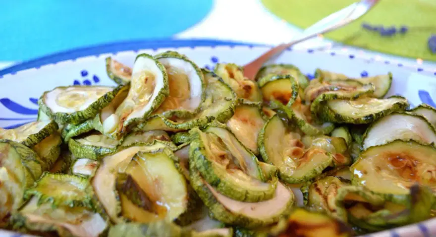 Zucchine in carpione, affettate e condite, pronte per essere gustate.