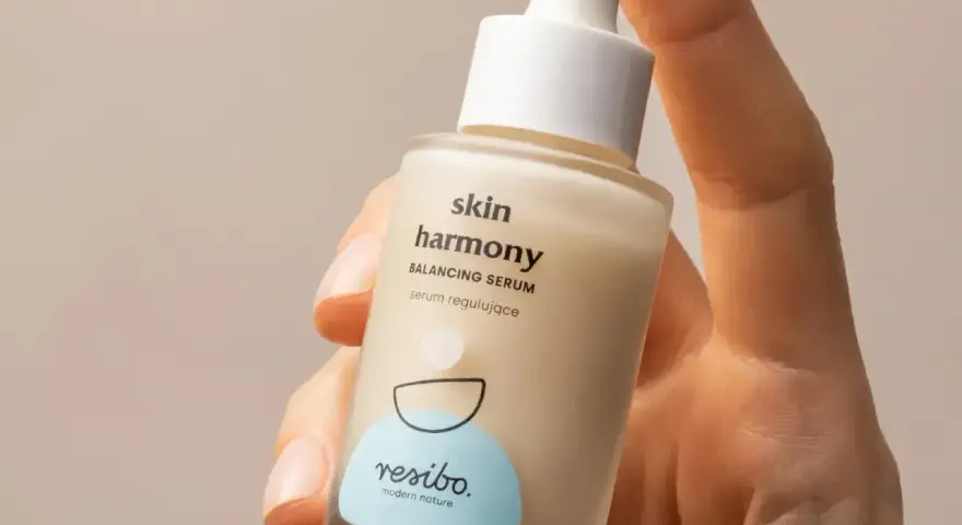 Dłoń trzyma buteleczkę serum Resibo Skin Harmony. Składnik alantoina dba o ukojenie skóry.