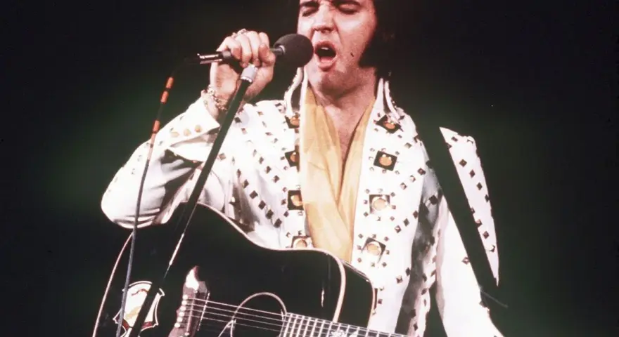 Elvis Presley singt mit Gitarre, trotz seiner bekannten elvis presley krankheit.