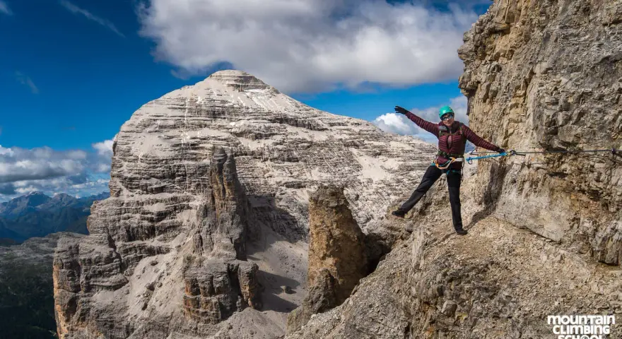 Kobieta na via ferrata, pokonująca skalną ścieżkę z ubezpieczeniem. To właśnie jest ferrata co to za przygoda!