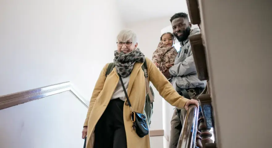 Glückliche Familie auf Treppe, die sich auf den Weg macht. Mit Ehe-Rechtsschutz ohne Wartezeit sind sie für alles gerüstet.