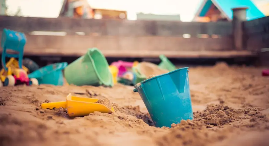 Jouets de plage dans le sable, prêts pour une demande de stage pratique BAFA.