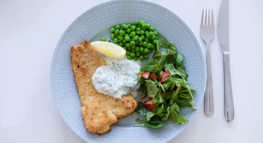 Panerad fisk med ärtor, sallad och en krämig skolans dillsås. En klassisk svensk rätt som smakar sommar.