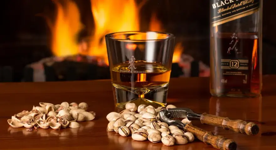 Przy kominku, kieliszek Johnnie Walker i pistacje. Idealny wieczór, czy whisky się chłodzi?