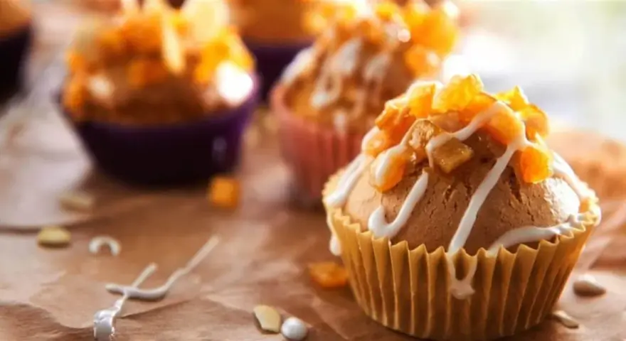 Słodkie muffinki czekoladowe kontra babeczki z nadzieniem, ozdobione lukrem i owocami.
