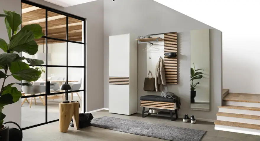 Modernen eingangsbereich gestalten: Garderobe, Bank, Spiegel und Teppich schaffen Ordnung. Ein Holzhocker und eine Pflanze setzen Akzente.