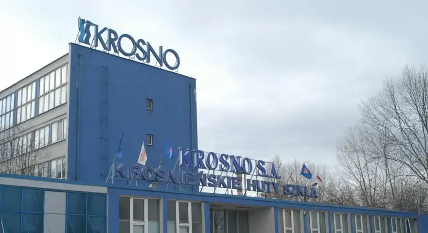 Niebieski budynek z napisem "KROSNO S.A. KROŚNIEŃSKIE HUTY SZKŁA".